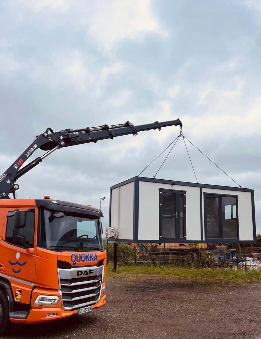 Camion-grue Quokka installant un module de base vie